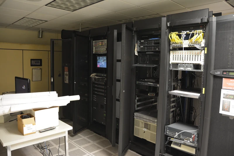 Rows of equipment racks inside a data center server room