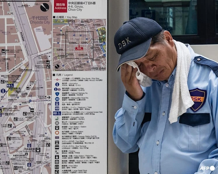 A security guard wipes his face during extreme heat in Tokyo on July 24, 2026