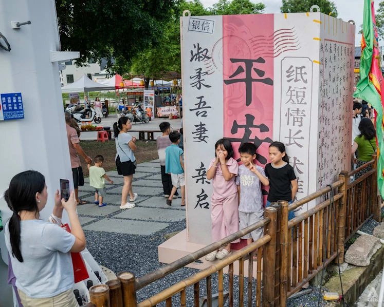 Visitors photograph a qiaopi-themed display in Xiqi Village, Jieyang