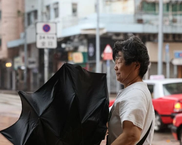 A pedestrian holds an inverted umbrella in strong wind and rain from Typhoon Noul in Hong Kong
